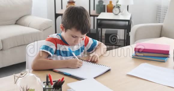 男孩在笔记本和纸上写作视频的预览图