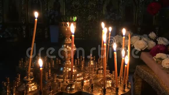 在黑暗的东正教或天主教大教堂或教堂的祭坛上燃烧的许多蜡烛宗教和信仰视频的预览图