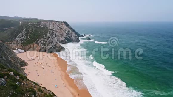 4普拉亚达阿德拉加海滩的鸟瞰图白色大西洋海浪向沙滩滚动游客休息视频的预览图