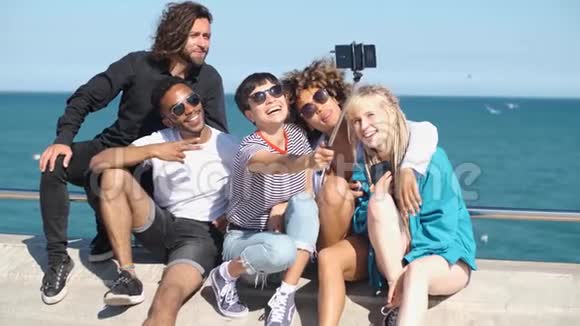 在海滨摆摆自拍照的快乐朋友视频的预览图
