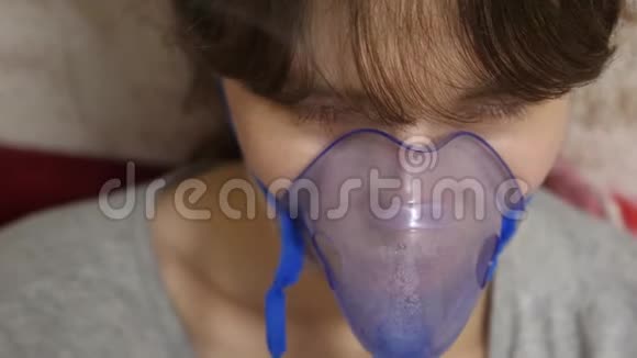 戴蓝色医院面具的女人吸入蒸气从呼吸道进入肺咳嗽治疗一个生病的女孩视频的预览图