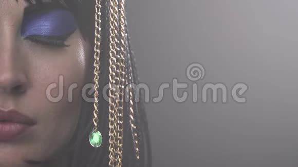 特写克利奥帕特拉脸配上蓝色的妆容和绿色宝石的金链视频的预览图