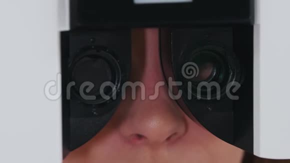 眼科治疗一名年轻妇女用特殊的验光设备检查视力更换镜片视频的预览图