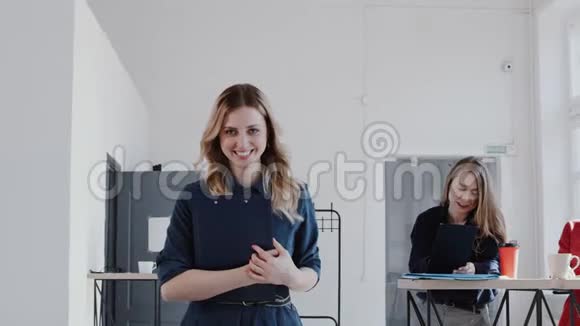 快乐成功的高加索商务女性走在现代办公室看着相机微笑慢动作红色EPIC视频的预览图