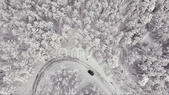 在冬季的暴风雪中在道路弯道停车空中观景视频的预览图