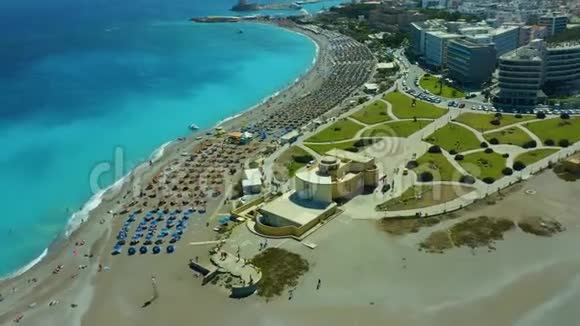 鸟瞰海滩和海滩有日光浴床和雨伞美丽的绿松石海的波涛拍打着视频的预览图