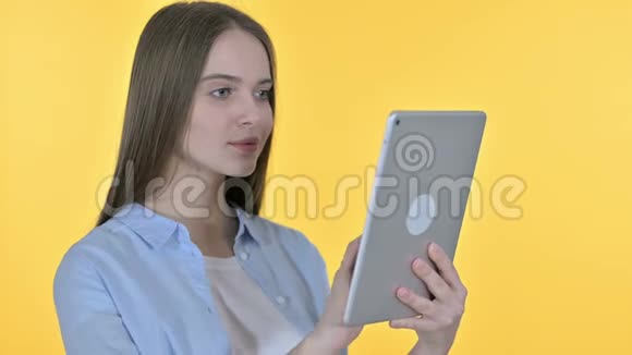 年轻女性使用平板电脑黄色背景视频的预览图