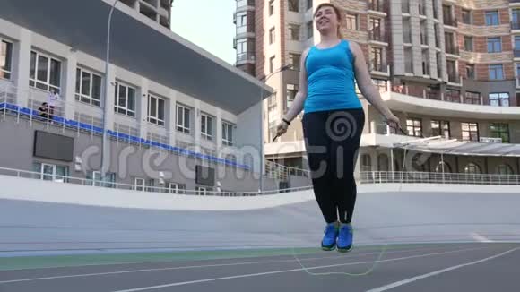 超重女性在运动场上跳绳视频的预览图