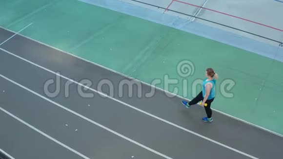 在体育场跑道上做步运动的妇女的鸟瞰图视频的预览图