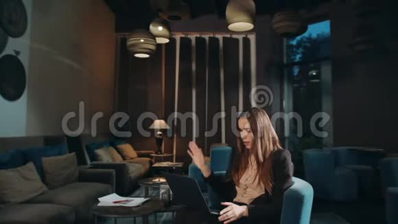 商务女性在酒店大堂用笔记本电脑在线进行视频聊天视频的预览图