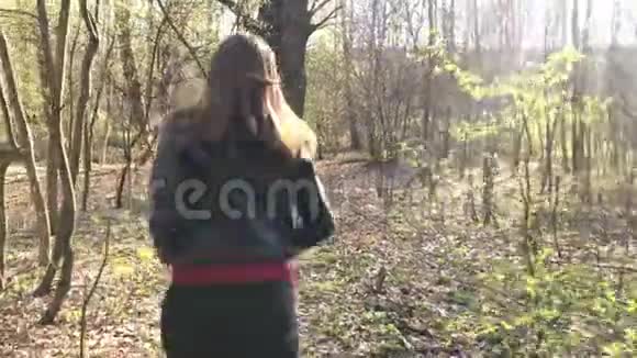 一个躲在树后森林里奔跑的女孩视频的预览图