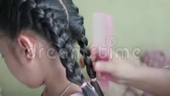 亚洲母亲在女儿的头发上做辫子视频的预览图