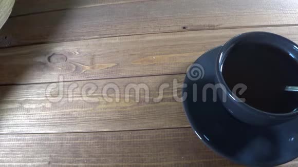 木桌上一杯黑咖啡和甜点服务员提供甜点视频的预览图