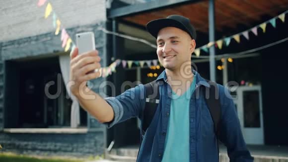 快乐男人用智能手机相机在户外自拍的慢动作视频的预览图