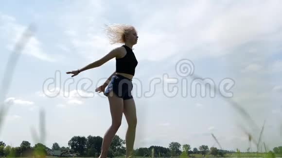 微笑的女孩跳在蹦床上在空中做绳子慢动作视频的预览图