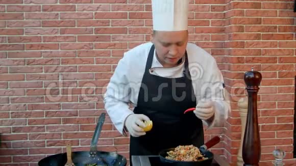 英俊的男厨师穿着白色制服装饰着海鲜饭看着镜头微笑视频的预览图