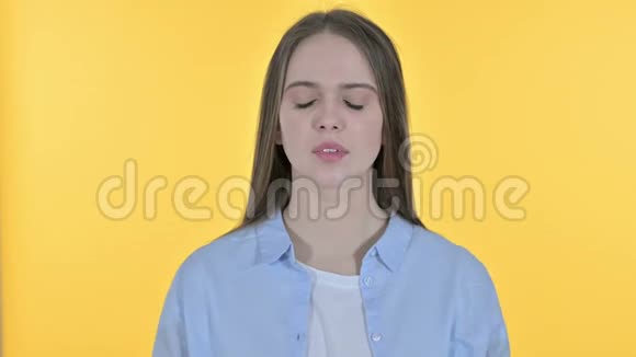 带头痛的休闲青年妇女黄色背景视频的预览图