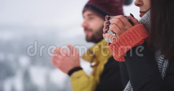 特写男女在山中神奇的地方喝着铁杯里的热茶欣赏视频的预览图