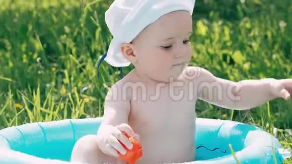 情绪激动的小男孩孩子沐浴在一个充气的游泳池里开怀大笑视频的预览图