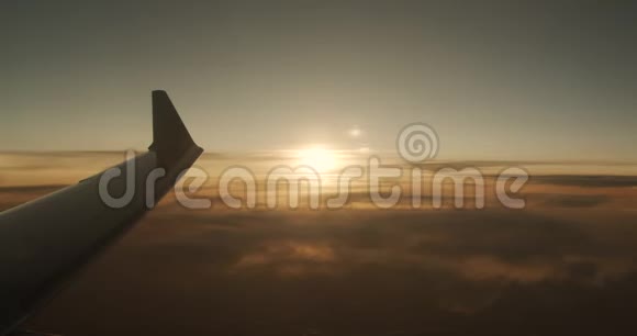 飞机在云层上方飞行红橙色日落视频的预览图