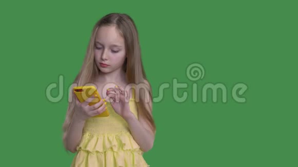 有着长长头发的少女正在用绿色钥匙背景浏览她的手机视频的预览图