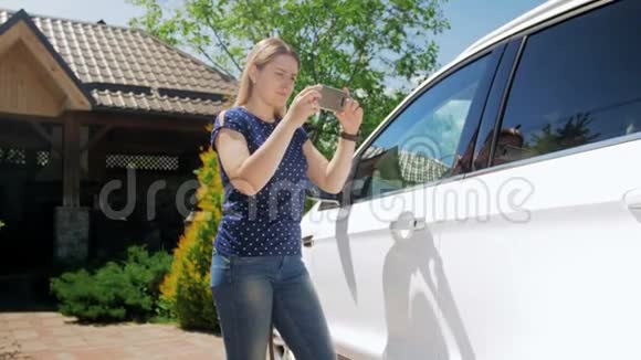 年轻女性制作汽车照片的视频在网上销售使用智能手机和拍照的女司机视频的预览图