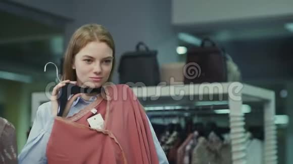 在服装店试穿衣服的女人做出红色的选择视频的预览图