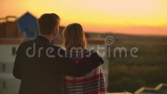 情人拥抱男女孩看日落酒站在楼顶慢镜头画面视频的预览图