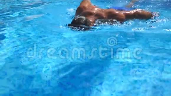 英俊的运动男子漂浮在游泳池与清澈的蓝色水年轻人在度假胜地游泳和娱乐视频的预览图