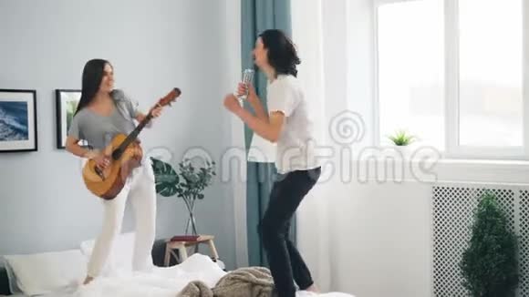 男女在床上遥控跳舞弹吉他唱歌开心视频的预览图