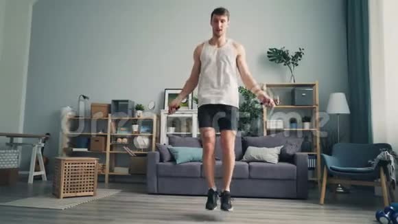 运动男学生在公寓里跳绳独自锻炼享受运动视频的预览图