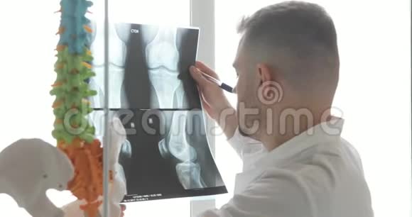 医生正在窗口附近学习x射线图像上的骨头视频的预览图