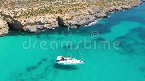 从高处俯瞰白色游艇和在科米诺马耳他岛上的天蓝色泻湖全景视频的预览图