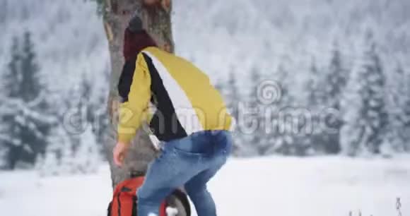 在雪山旁边的一位游客拿着他的大橙色包继续他的冒险探索视频的预览图