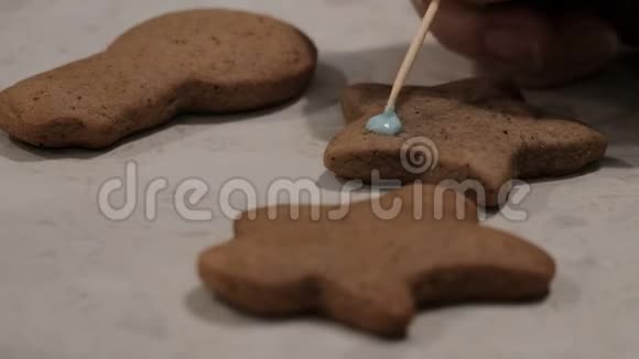圣诞饼干躺在桌子上孩子们用一种蓝色的奶油用一种星号形状的姜饼饼干视频的预览图