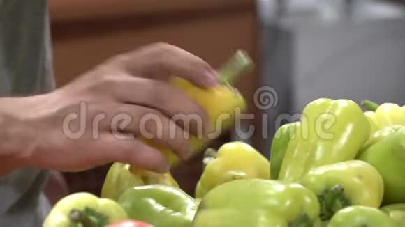 主题在超市买蔬菜一个年轻的白种人的特写镜头他的手选择了一个绿色的黑胡椒视频的预览图