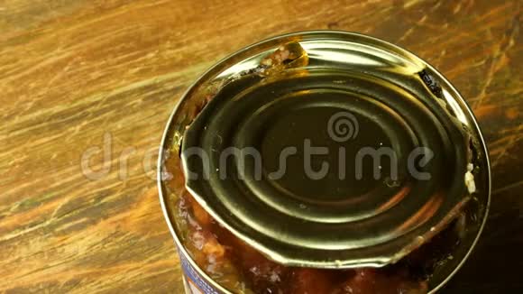 罐头肉人类用菜刀在木桌上用锡罐切割一块炖肉特写镜头视频的预览图