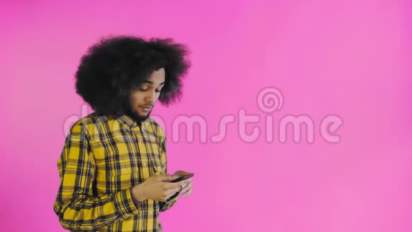 快乐迷人的年轻非洲裔美国人使用电话和获得好消息的紫色背景情感概念视频的预览图