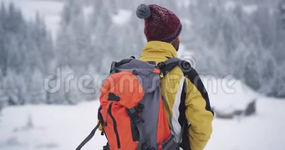 一个年轻的游客在冬天独自穿越高山他探索风景美丽的时光视频的预览图