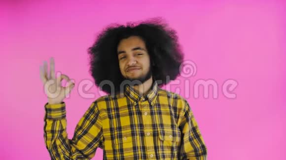 微笑迷人的非裔美国人表现出良好的姿态同时站在紫色背景上孤立概念视频的预览图