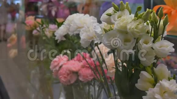多种颜色的新鲜生机勃勃的花盆展示成排出售旁边的花店在商场里人们视频的预览图
