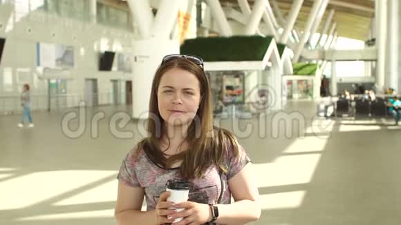 咖啡时间漂亮的女人坐在机场休息室喝咖啡视频的预览图