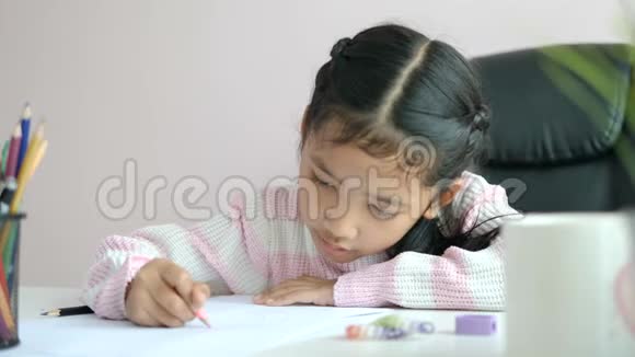 小亚洲女孩用铅笔在纸上写作业微笑着为教育理念选择焦点视频的预览图
