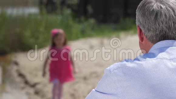 散焦的女孩跑向她的祖父拥抱他她看着框架微笑着4K慢慢视频的预览图