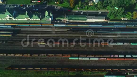 在火车站附近铁路上行驶的旅客列车的空中镜头4K视频的预览图