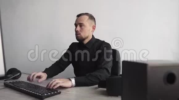 年轻的胡须男开始使用vr耳机坐在电脑旁试图触摸或点击一些东西视频的预览图
