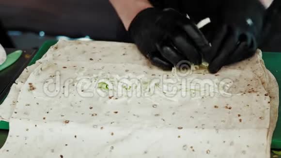 将厨师手中的手套贴在沙瓦玛的皮塔原料上视频的预览图