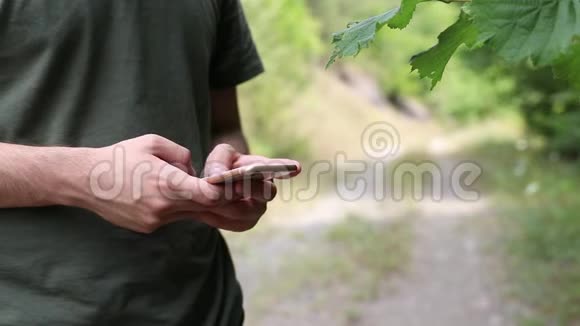 在森林里打电话的男青少年视频的预览图