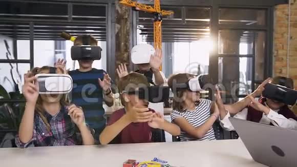 在计算机编码课上使用虚拟现实耳机的小学快乐小学生小组视频的预览图