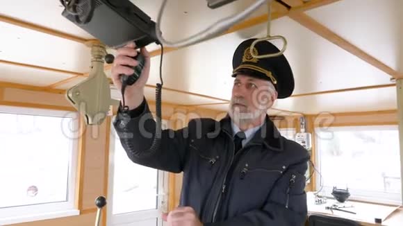 有胡子的船长在船长桥上设置无线电导航干事管理导航面板上的设备视频的预览图